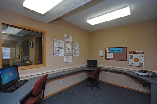 A room with a desk, chair, and laptop.