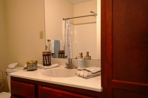 A bathroom with a white sink and a mirror.