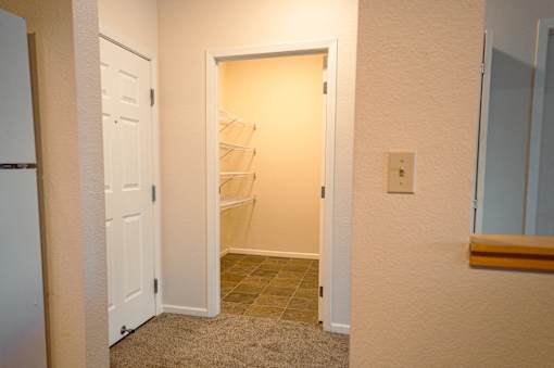 A white door is open to a hallway with a light on.