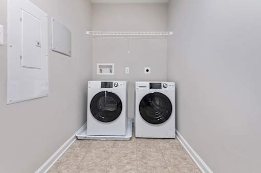 Two front loading washing machines in a laundry room.
