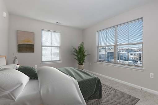 A bedroom with two beds and a large window.