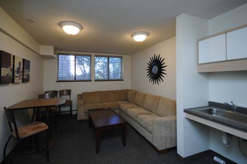 A living room with a couch, table, and chairs.
