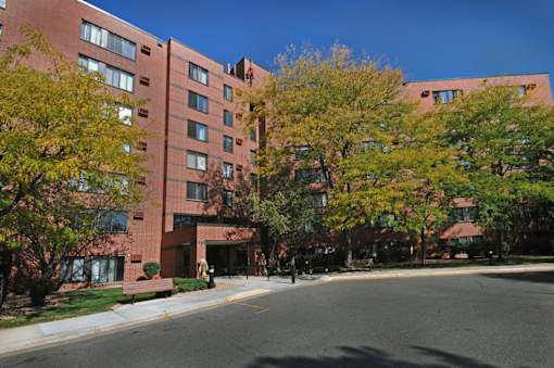 A red brick building with trees in front of it.