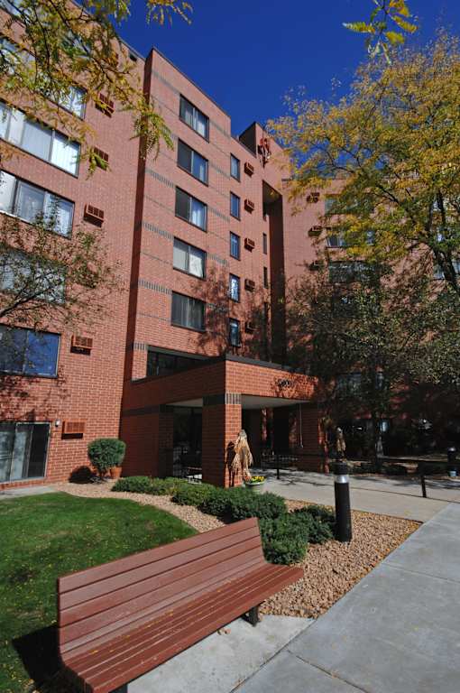 A red brick building with a woman walking in front.