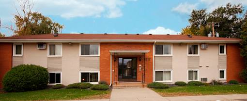 A brown and beige building with a brown door and windows.