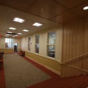 A long hallway with a red carpet and white walls.