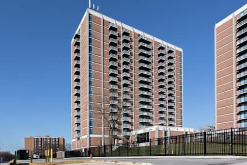A tall red brick building with balconies on the side.