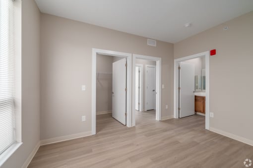 a living room with a hard wood floor and a door to a bathroom