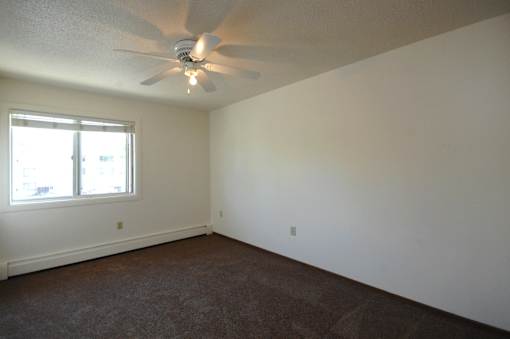 A room with a ceiling fan and a window.