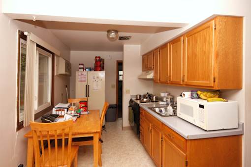 A kitchen with wooden cabinets and a table.