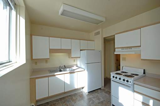 A kitchen with white appliances and cabinets.