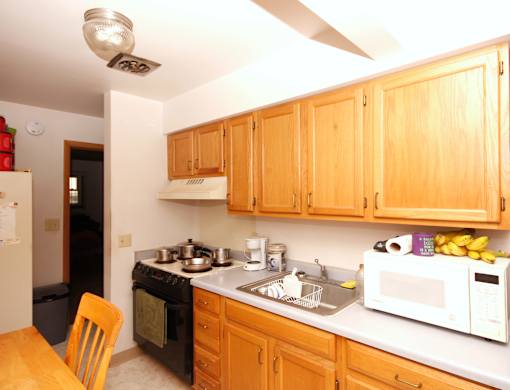 A kitchen with wooden cabinets and a white microwave.