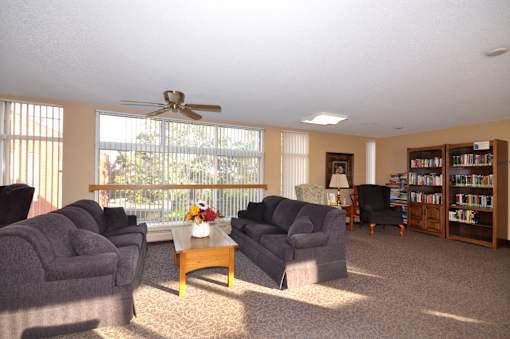 A living room with a ceiling fan and a large window.