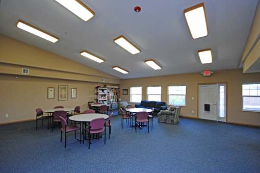 A room with tables and chairs and a fire extinguisher on the ceiling.
