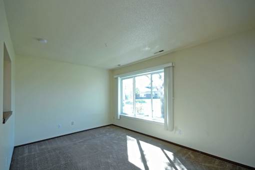 A room with a window and a grey floor.