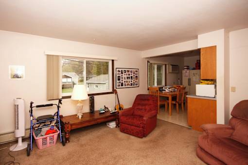 A living room with a red chair and a wooden bench.