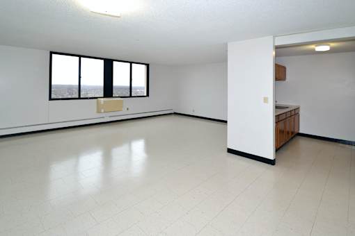 A large, empty room with a window overlooking a cityscape.