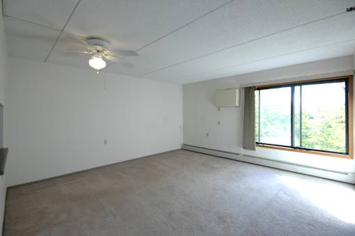 A room with a ceiling fan and a window.