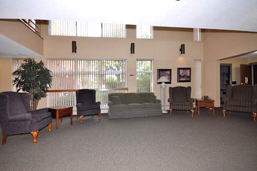 A living room with a grey carpet and furniture.