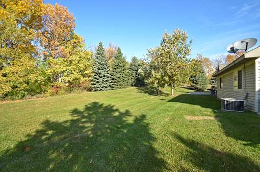 A backyard with a lawn and trees.