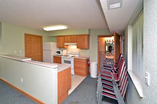 A kitchen with a white fridge and wooden cabinets.