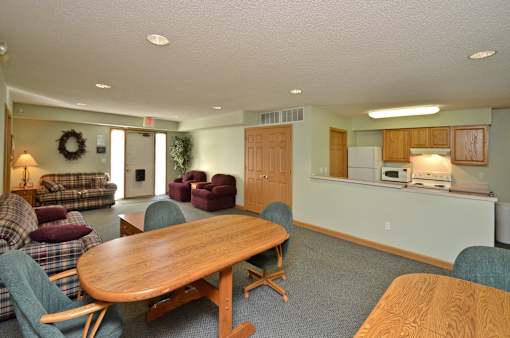 A living room with a couch, chairs, and a dining table.
