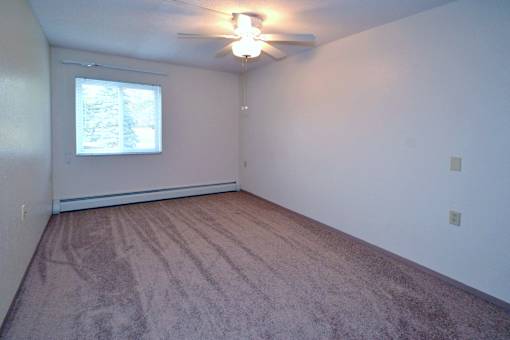 A room with a ceiling fan and a window.