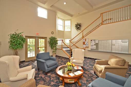 A living room with a staircase and a calendar on the wall.