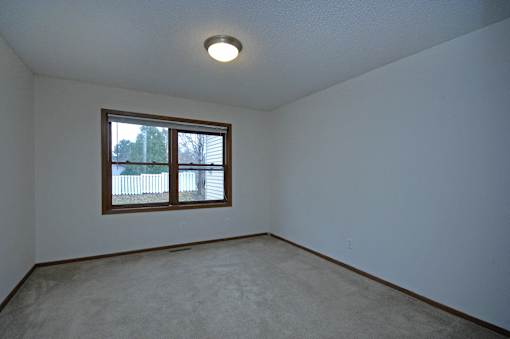 Empty room with a window and a ceiling light.