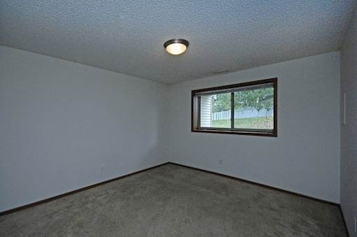 A room with a window and carpeted floor.