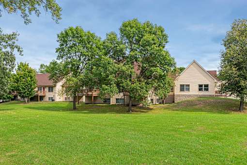 A large grassy area with a house and trees in the background.