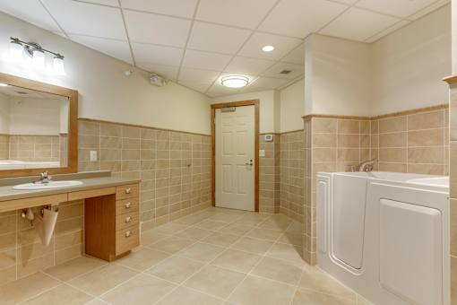 A bathroom with a sink, mirror, and bathtub.
