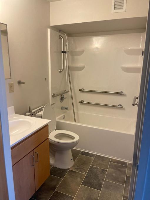 A bathroom with a toilet, sink, and shower.