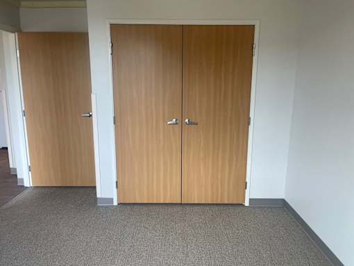 Two brown doors in a white room.