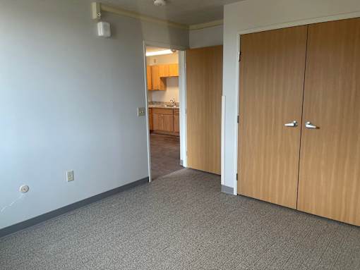 A room with a white wall and a wooden door.
