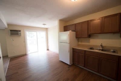 A kitchen with brown cabinets and a white fridge.