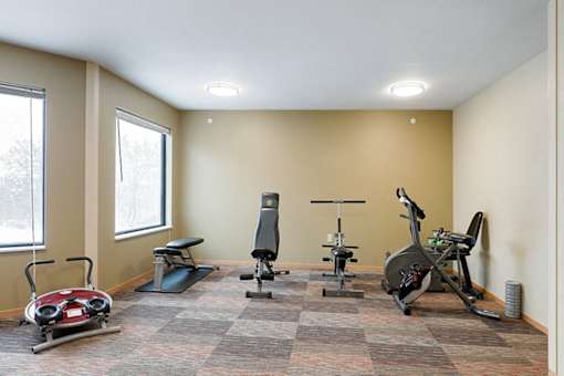 A room with exercise equipment and windows.