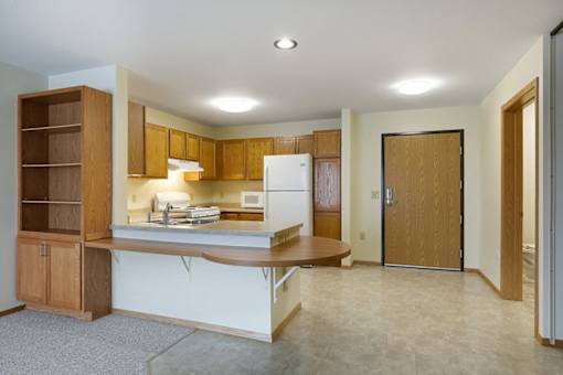 A kitchen with a white fridge and wooden cabinets.