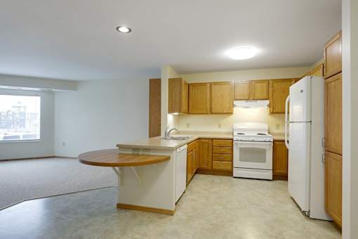 A kitchen with white appliances and wooden cabinets.