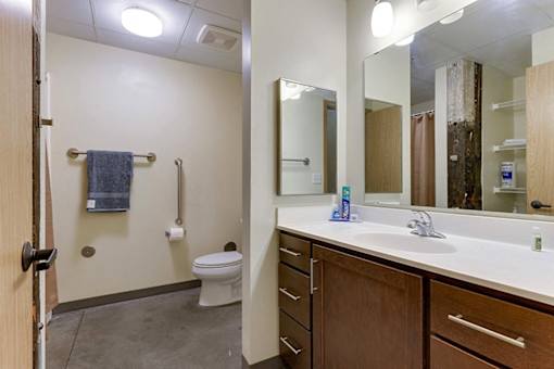 A bathroom with a toilet, sink, and mirror.
