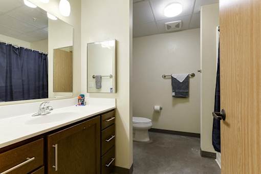 A bathroom with a toilet, sink, and mirror.