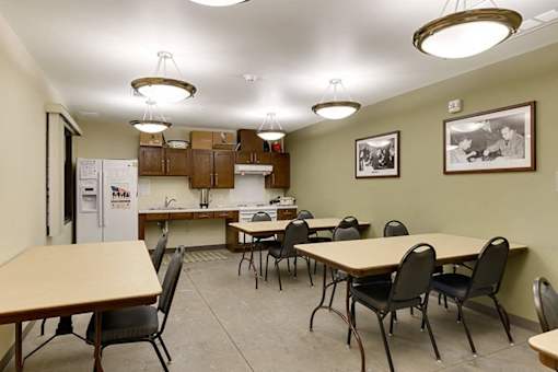 A kitchen area with a table and chairs.