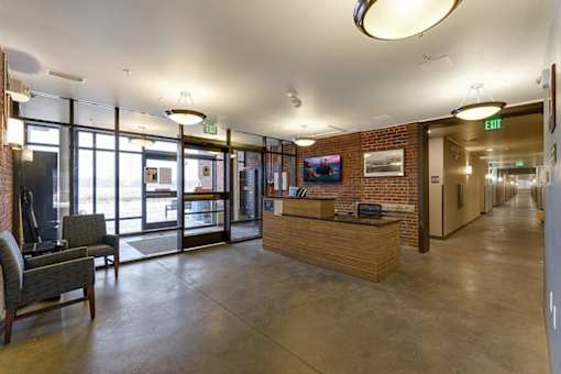 A reception area with a brick wall and a wooden reception desk.