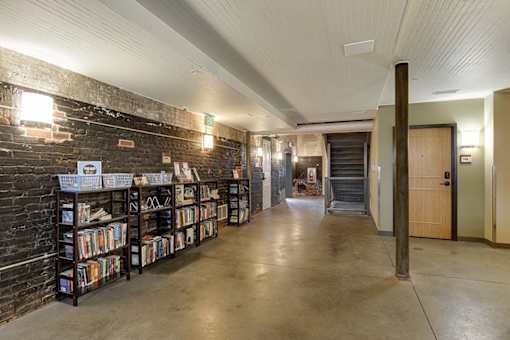 A library with bookshelves and a concrete floor.