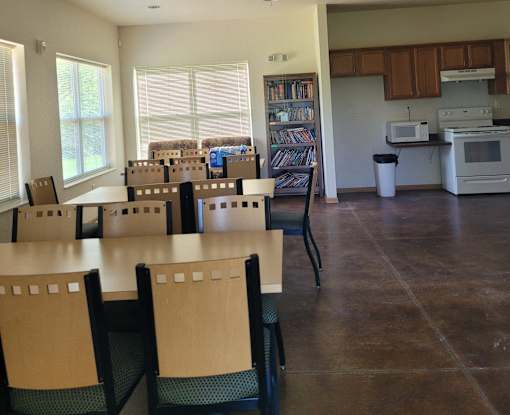 A kitchen with a dining table and chairs.
