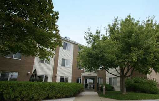 A building with a green tree in front of it.