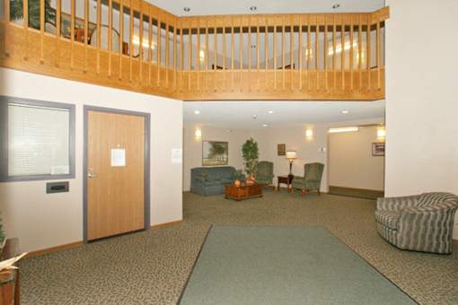 A room with a carpeted floor and a wooden balcony.