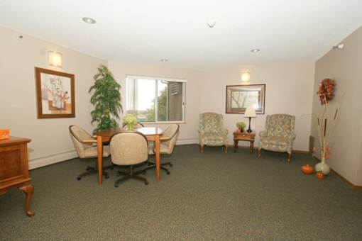 A room with a table and chairs and a potted plant.