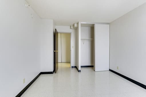 A white hallway with two doors and a wall-mounted light fixture.