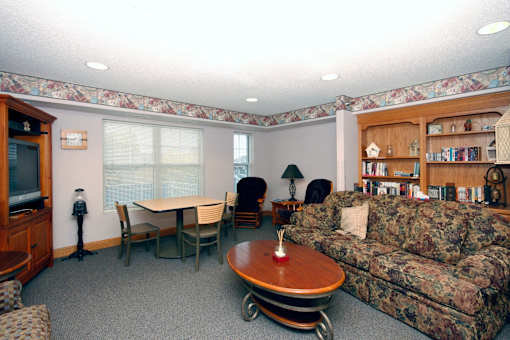 A living room with a couch, chairs, and a television.